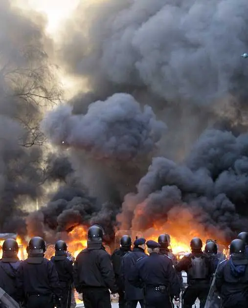Демонстранти край подпалената сграда на президентския дворец. Останалите снимки вижте в галерията отгоре.
