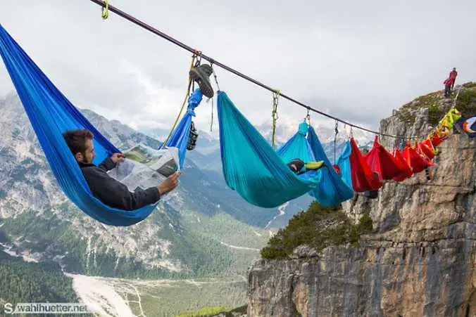 Група приключенци спят на хамаци, висящи на десетки метри над земята