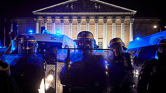 Френският президент Еманюел Макрон на фона на протестите в страната