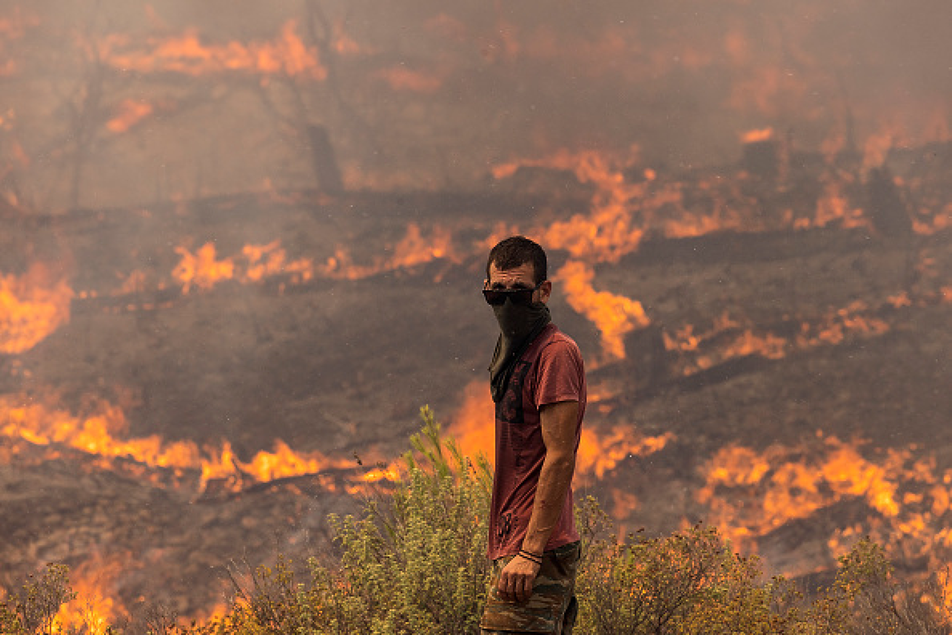 Доброволец, готов да се бори с пламъците, които поглъщат хълм в Аполана, Родос. Снимка: Getty Images