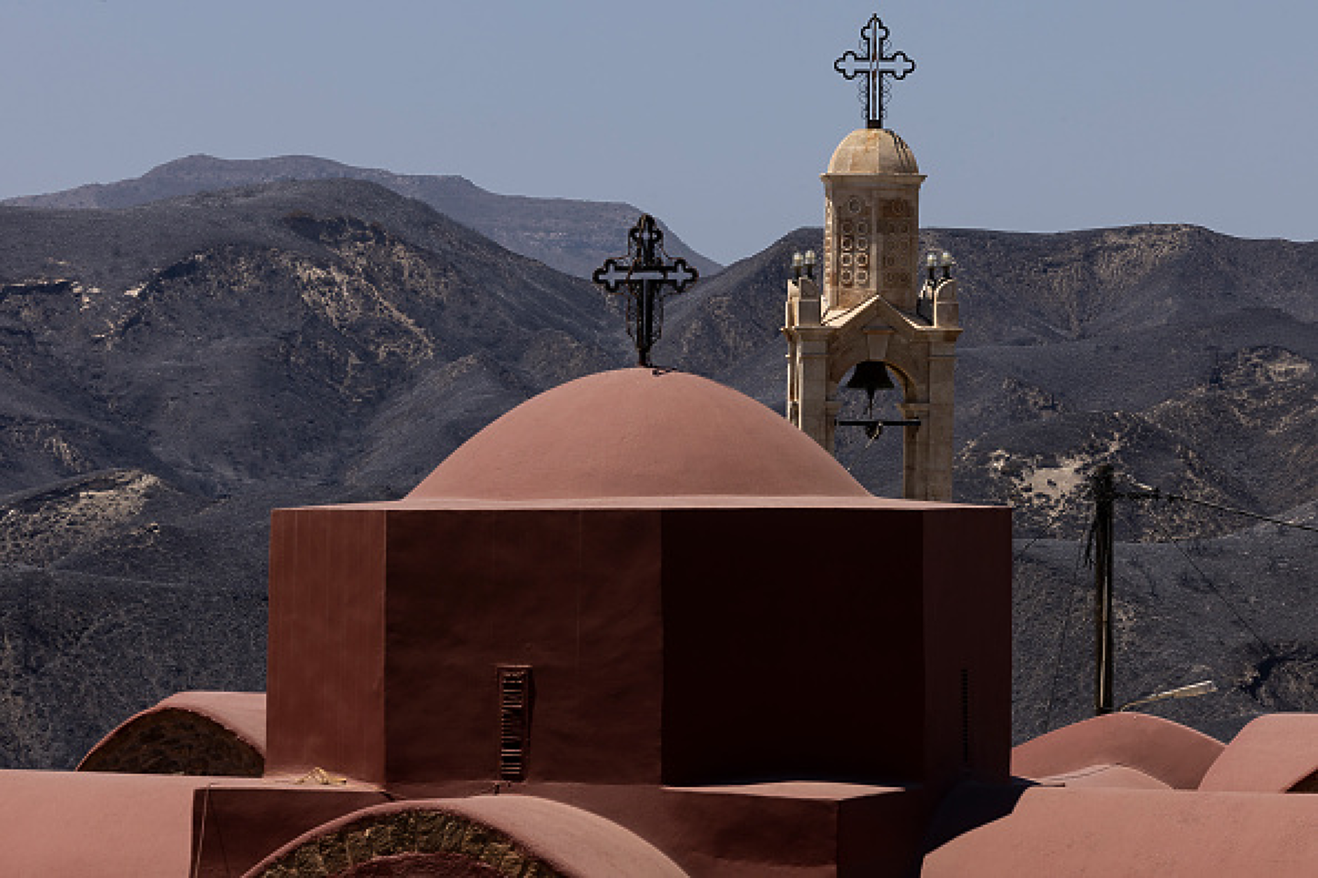 Изгорели планински склонове се виждат зад гръцка православна църква в Асклипио, Родос, Гърция. Снимка: Getty Images