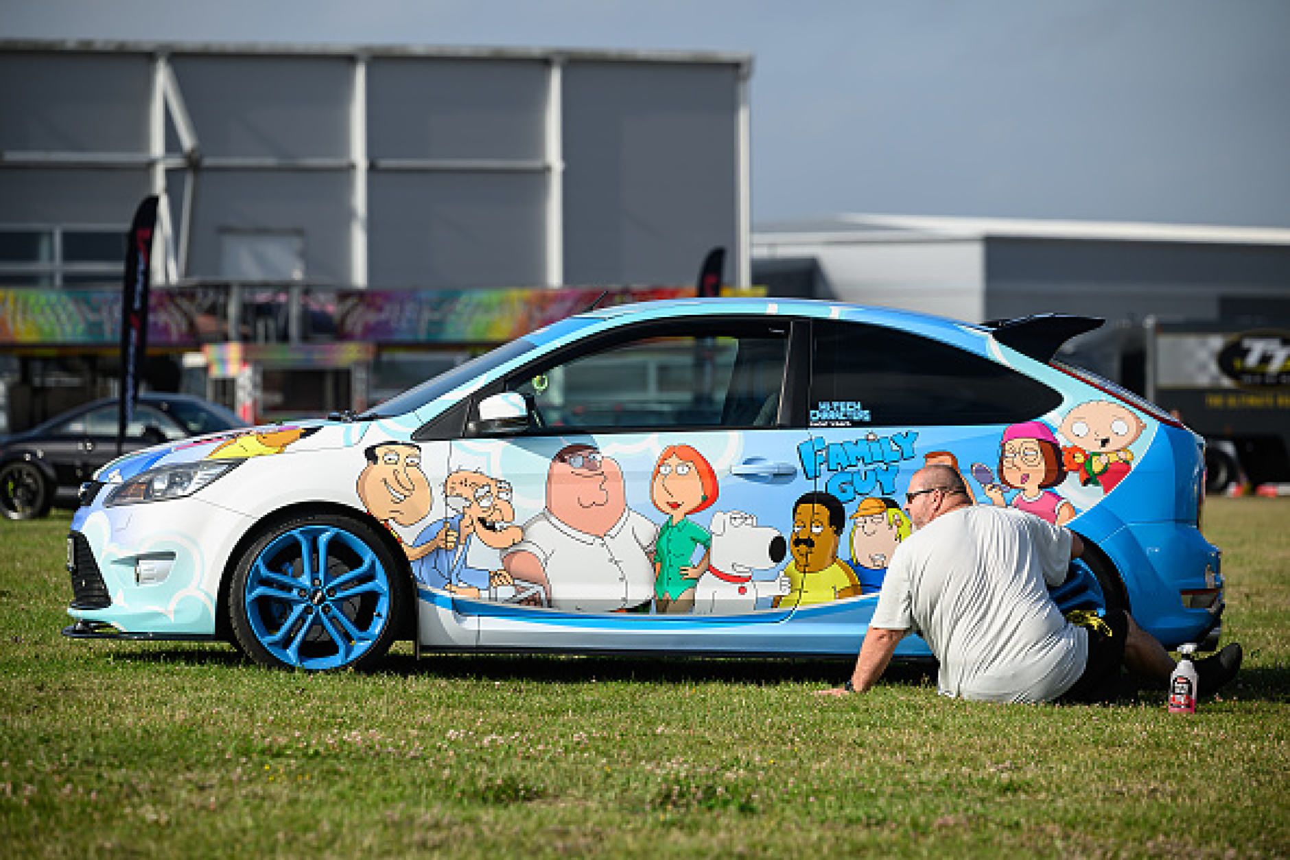 Участник в една от изложбите полира джантите на своя тематичен автомобил "Family Guy".  Снимка: Getty Images