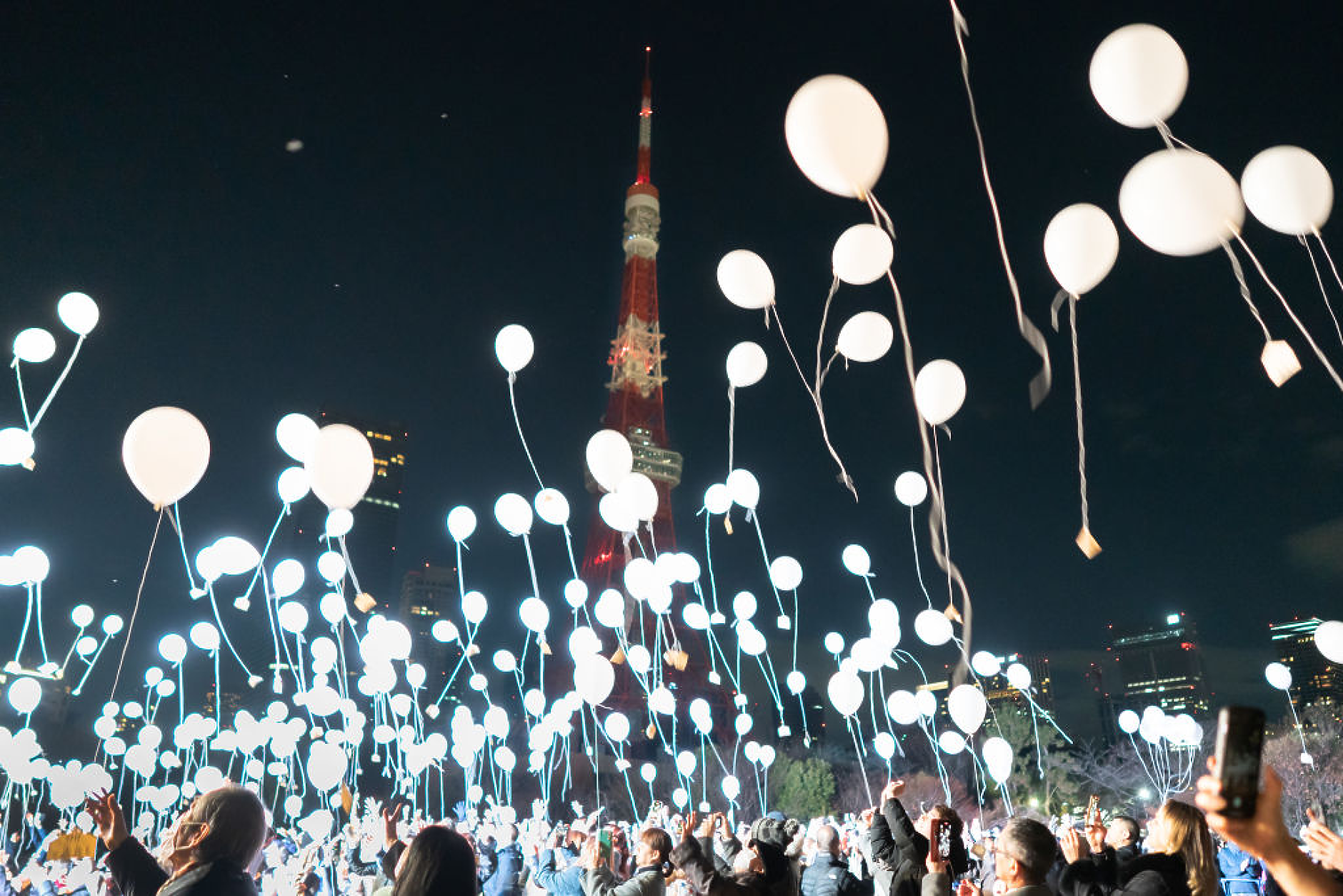 Хората пускат балони пред Токийската кула по време на новогодишните тържества в Токио, Япония. /Снимка: Getty Images