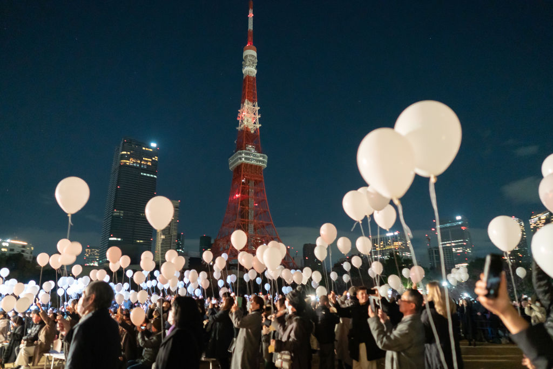 Хората пускат балони пред Токийската кула по време на новогодишните тържества в Токио, Япония. /Снимка: Getty Images
